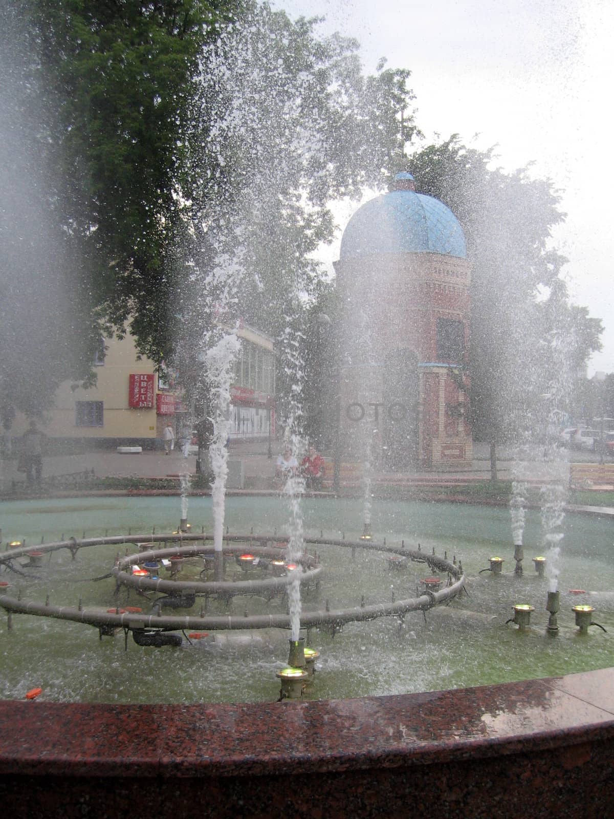Very beautiful fountain with strong jets on a chapel background
