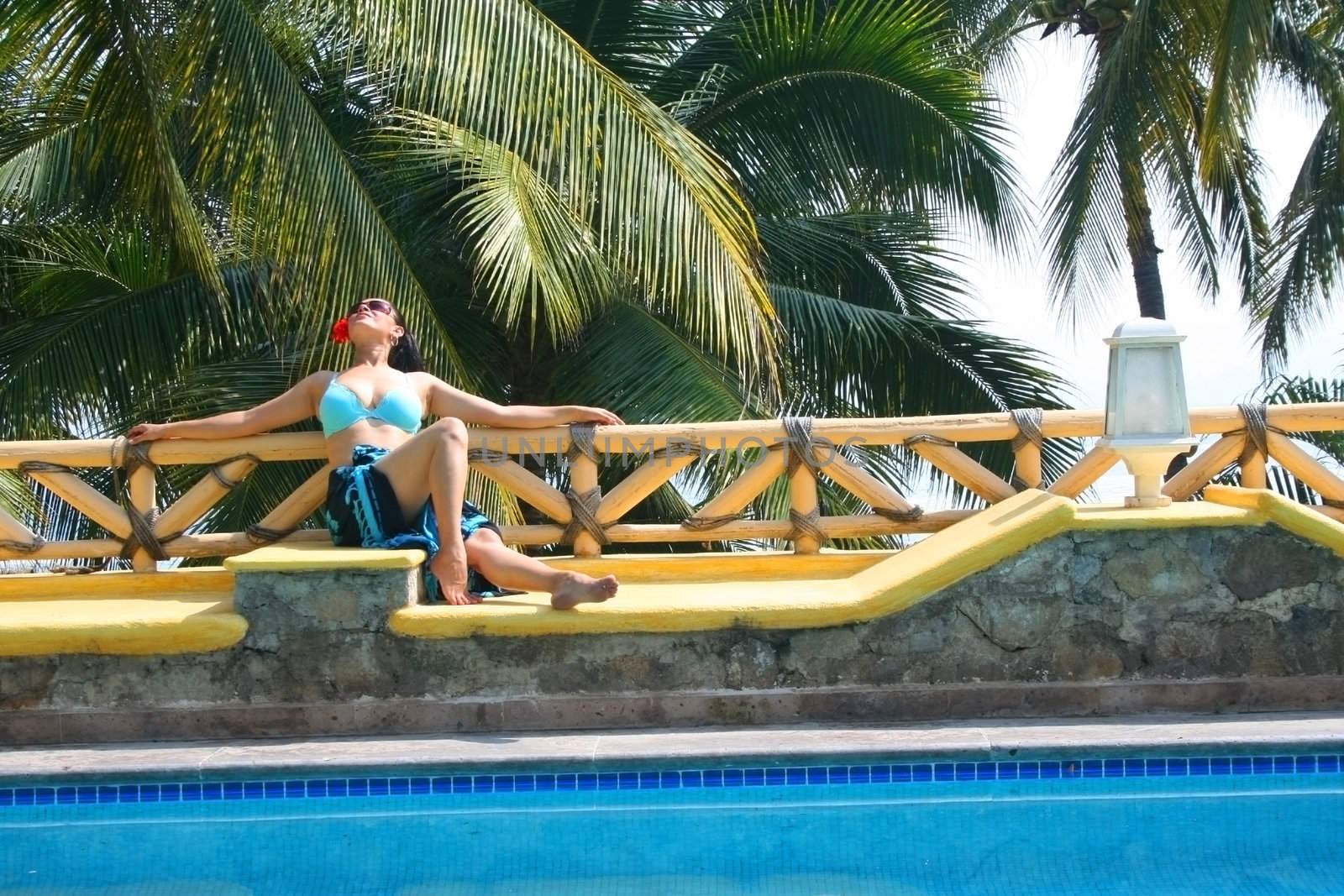Young latino woman next to pool