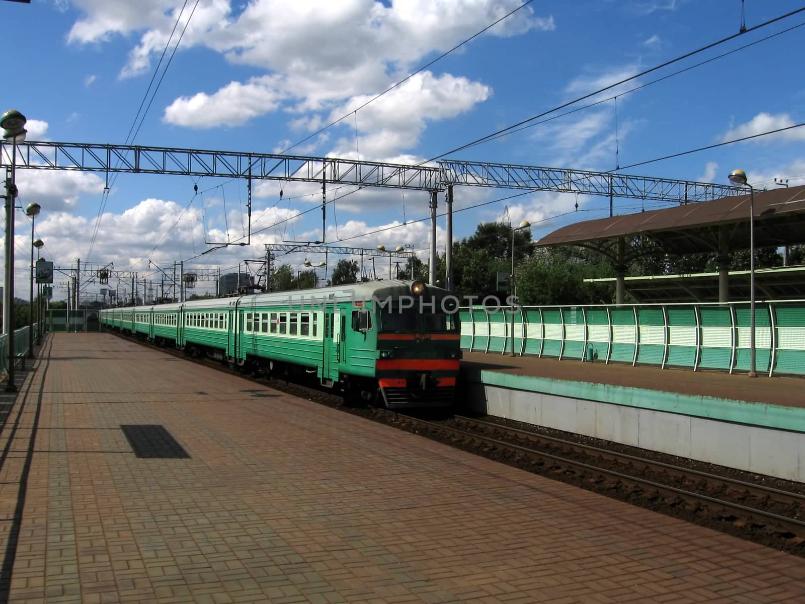 Green fast Russian train moves to the station