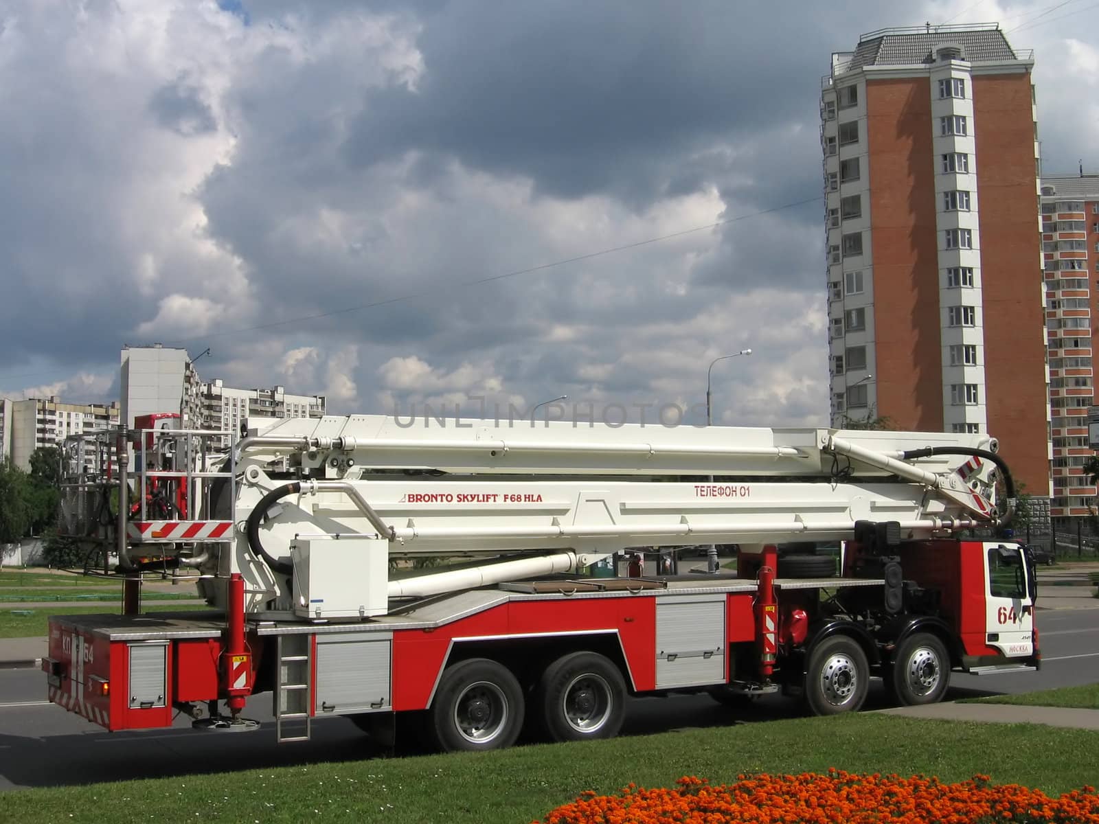 Very beautiful long fire truck in Moscow on a background of gray clouds