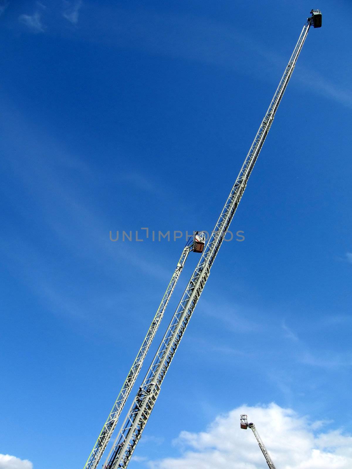 Very high metal fire ladders on a background of blue sky