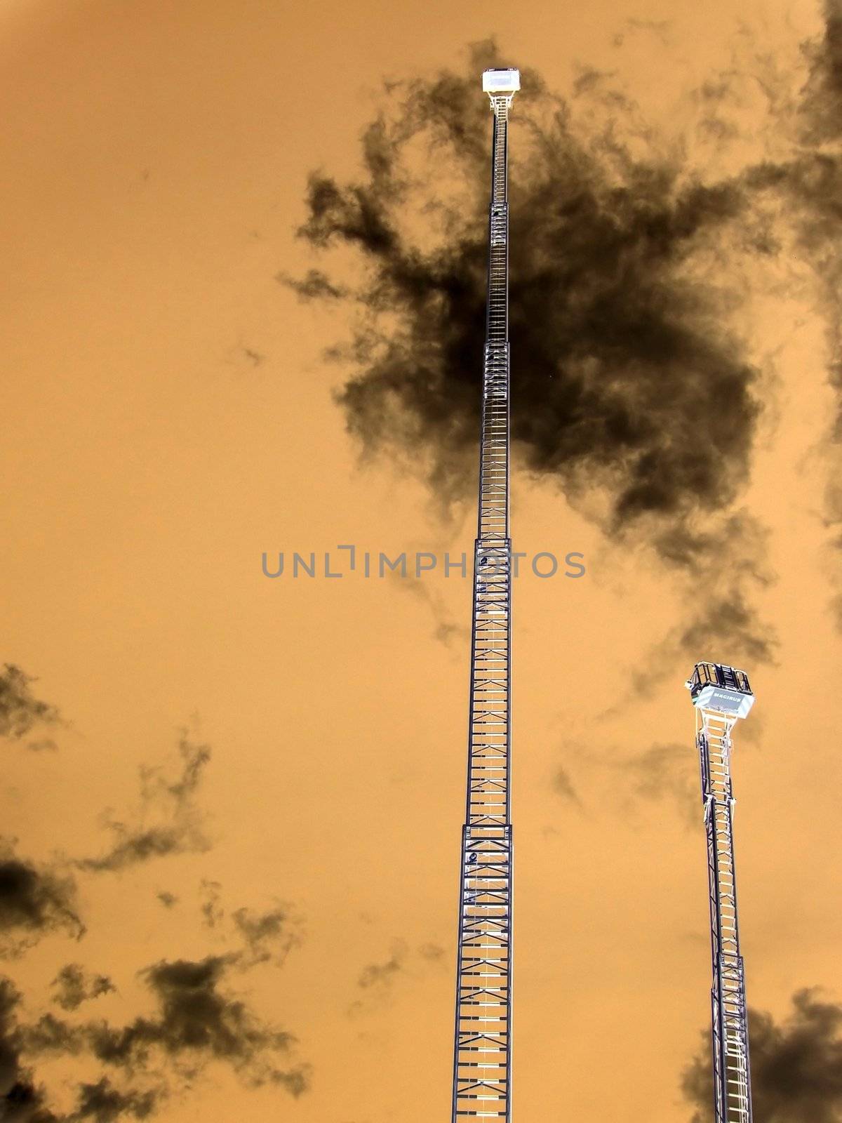 Very high metal fire ladders on a background of red sky