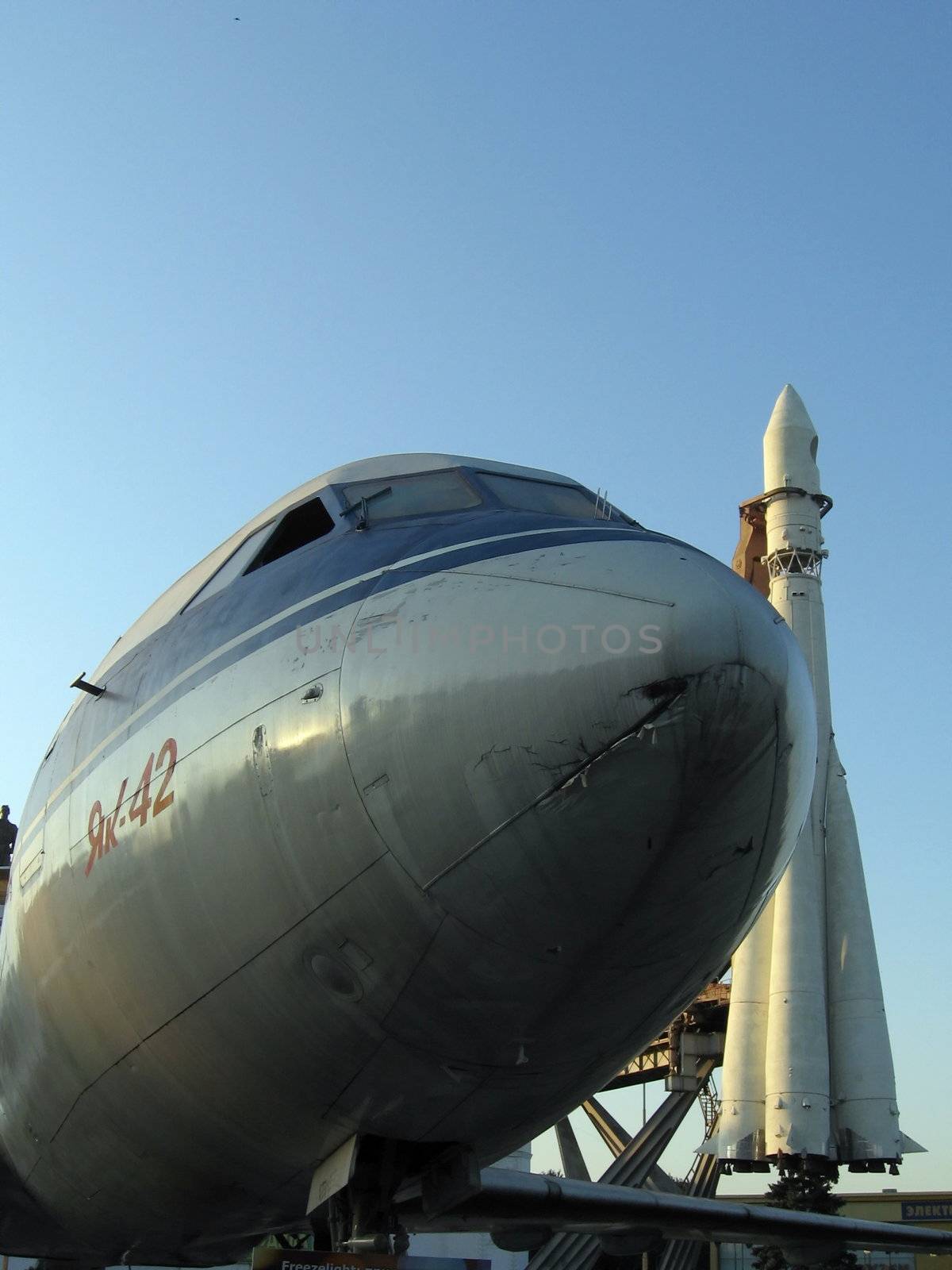 Rocket with the plane in front on a background of blue sky