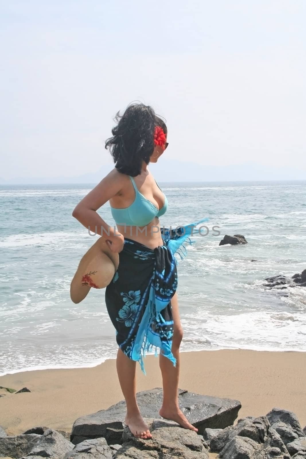 Young Latin woman sitting on beach