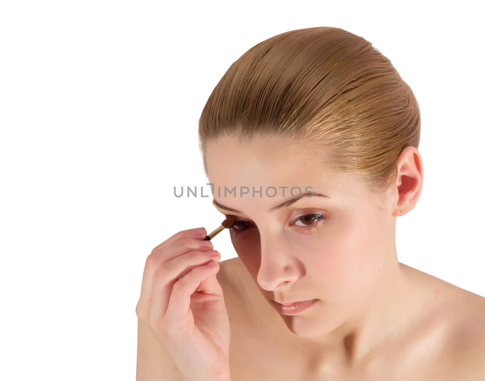 young woman putting make up on her face. Isolated