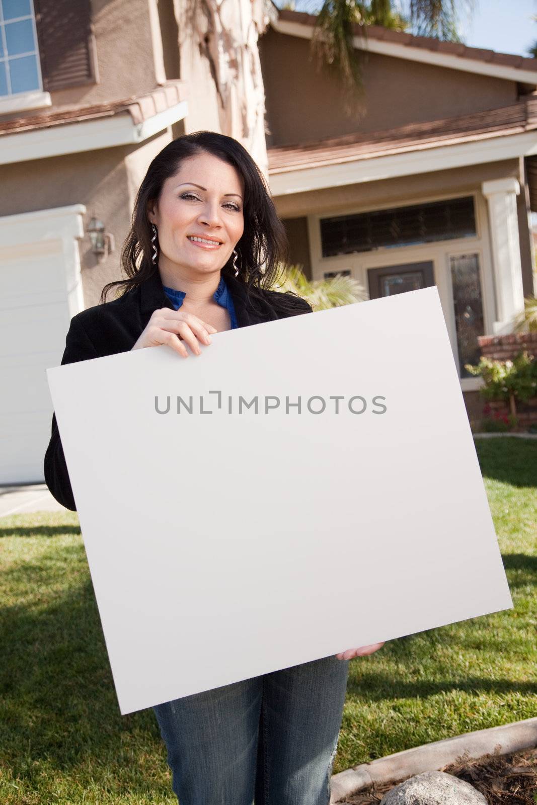 Attractive Hispanic Woman Holding Blank Sign in Front of House by Feverpitched