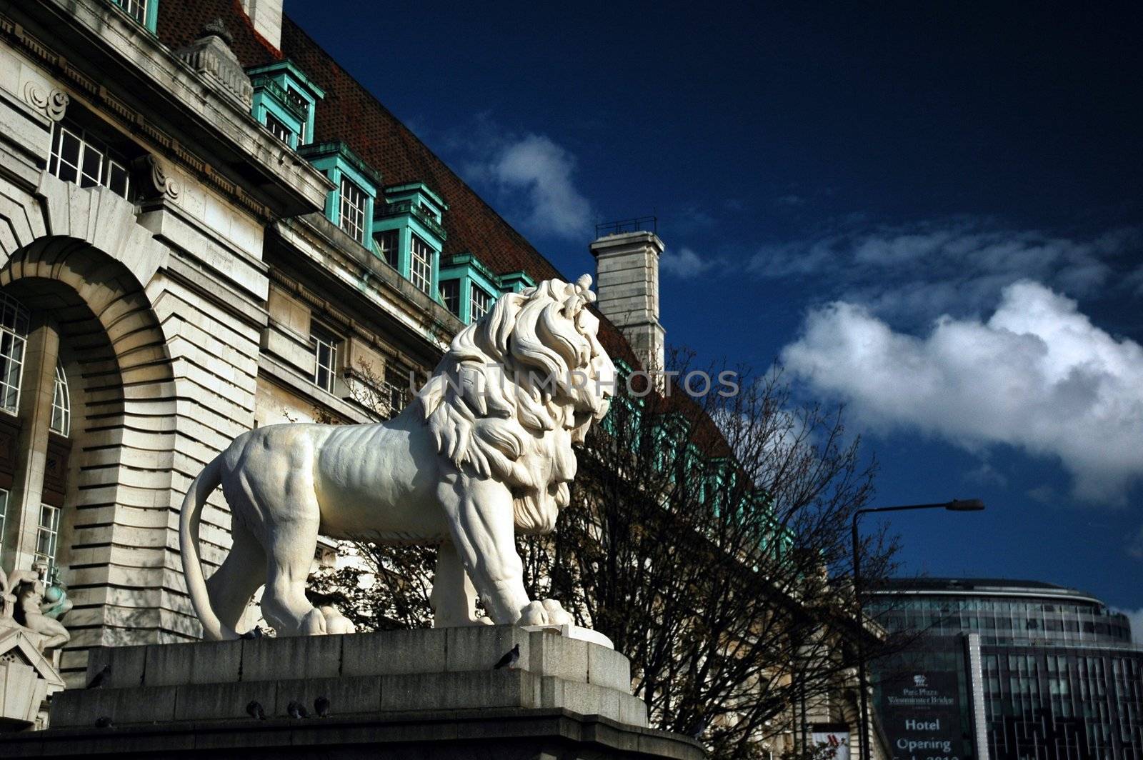 sculpture od white lion with buillding opposite London eye