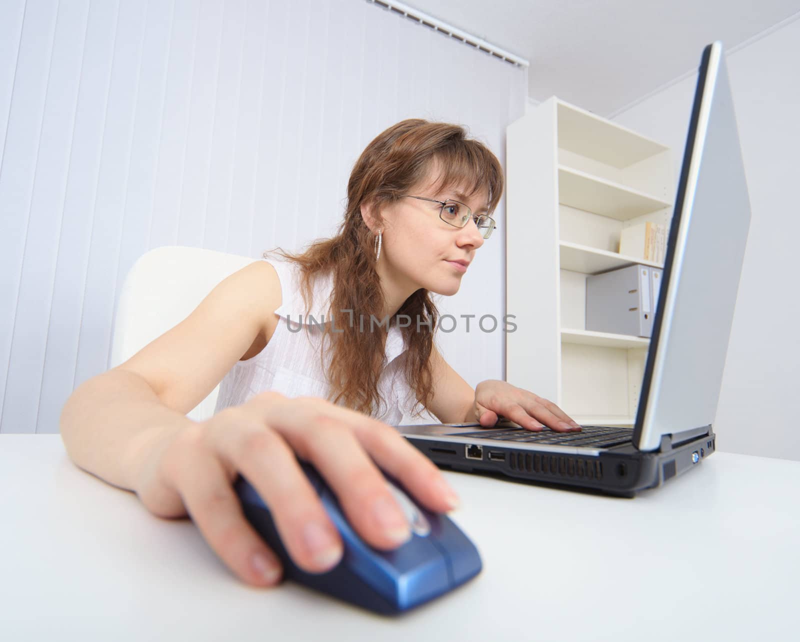 Amusing woman attentively studies Internet by means of laptop by pzaxe