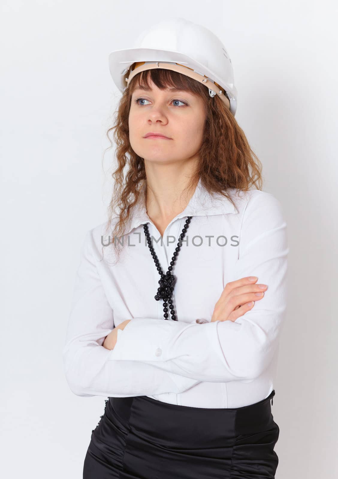 The serious young woman the engineer - builder in a white helmet