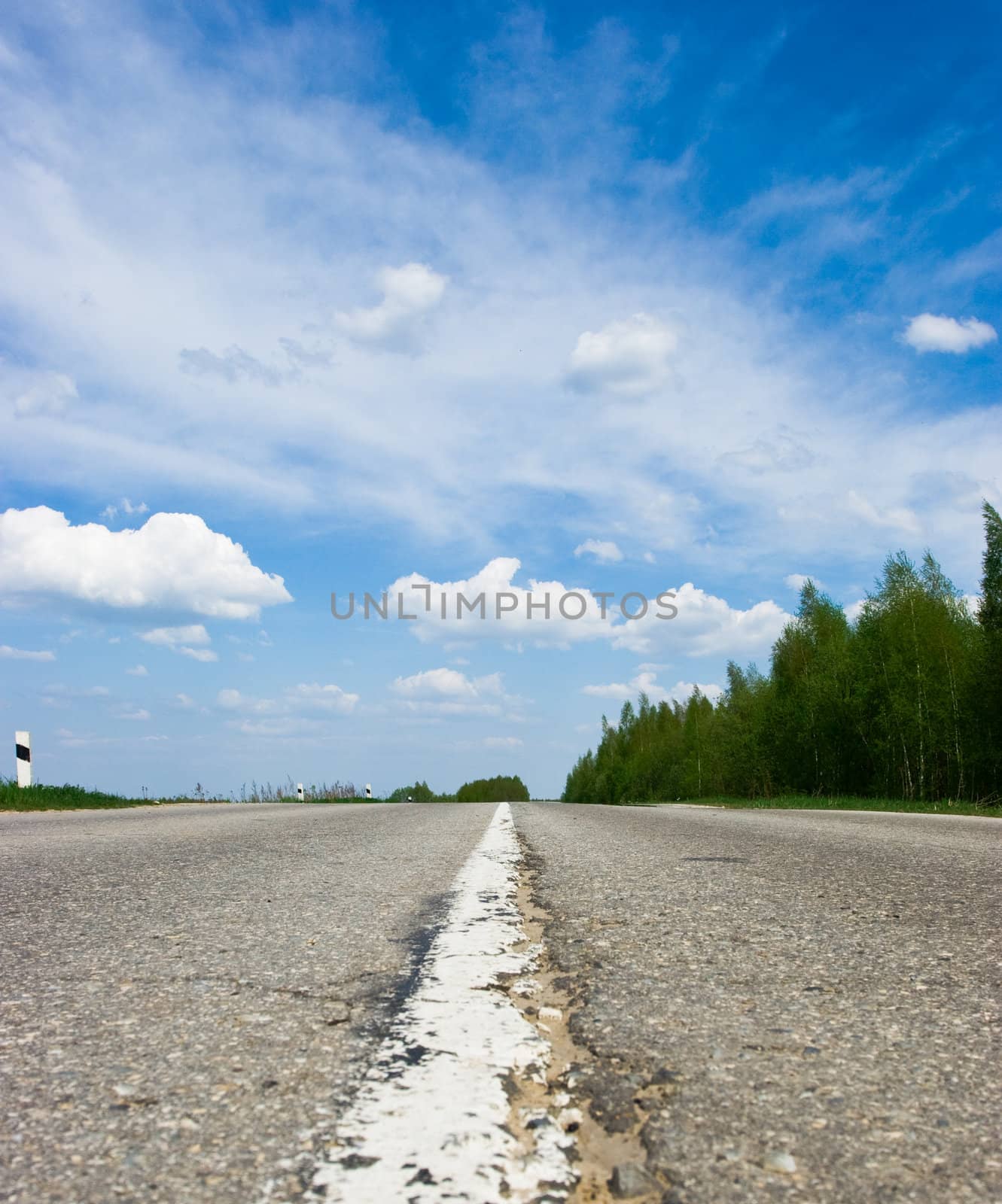 Open road against blue sky with clouds