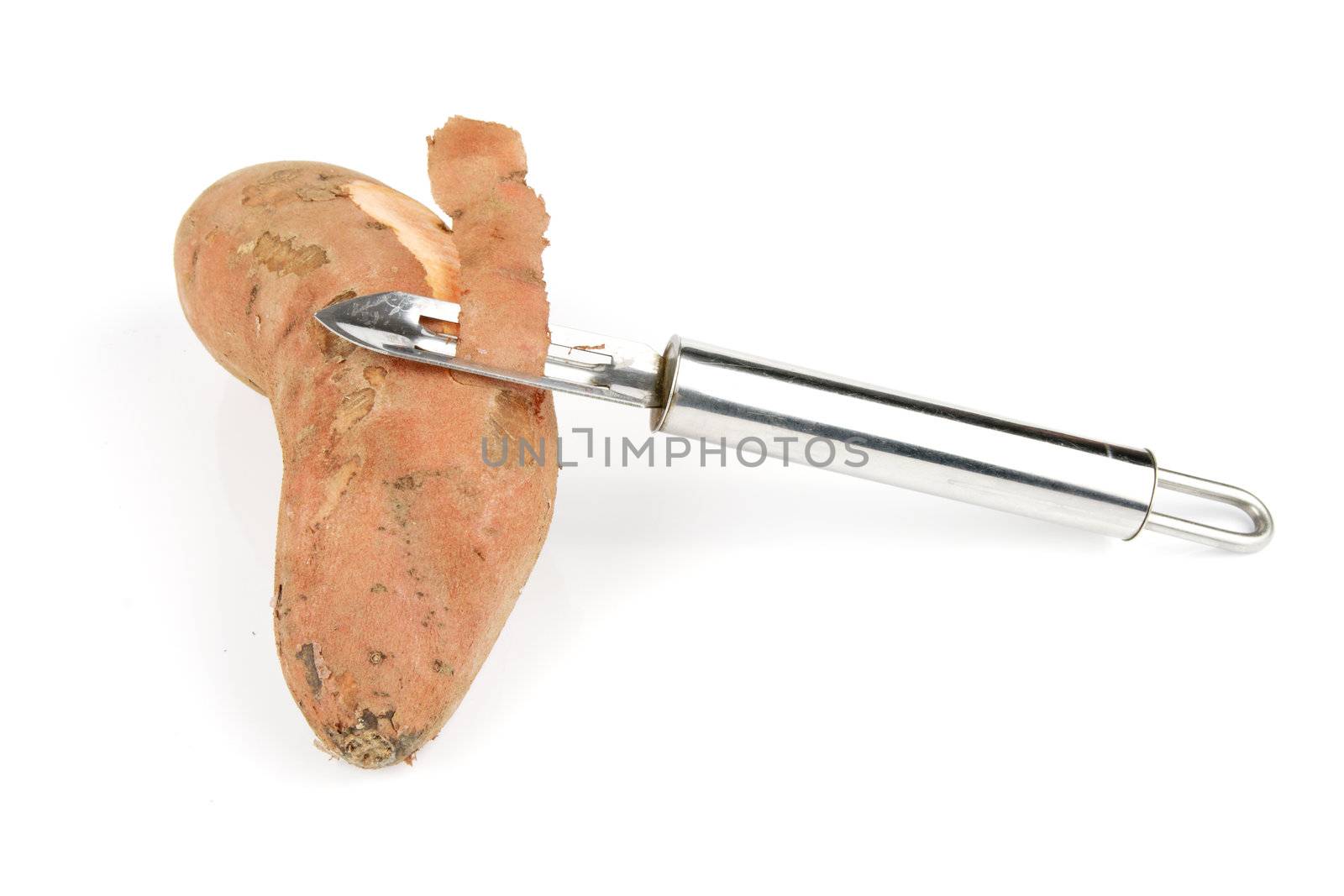 Sweet Potato cut in half with a silver potato peeler on a reflective white background