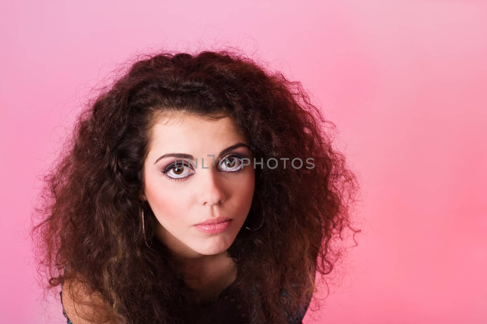 Uncheerful young woman on pink