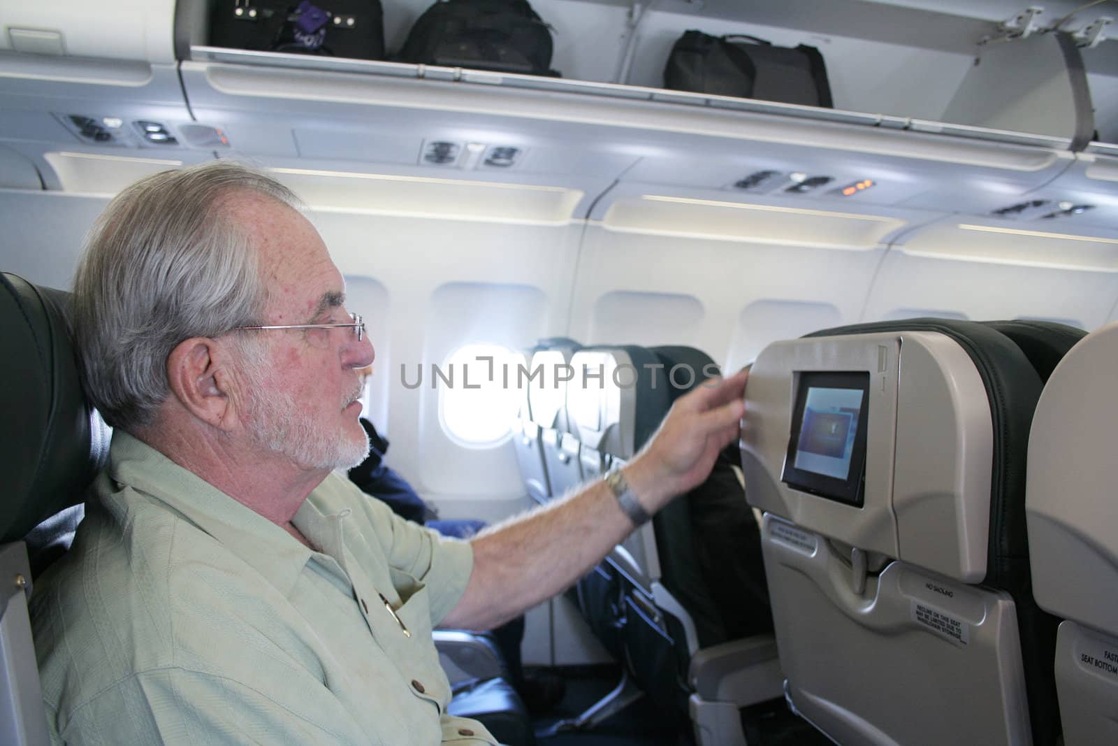 Man on airplane looking at inflight tv