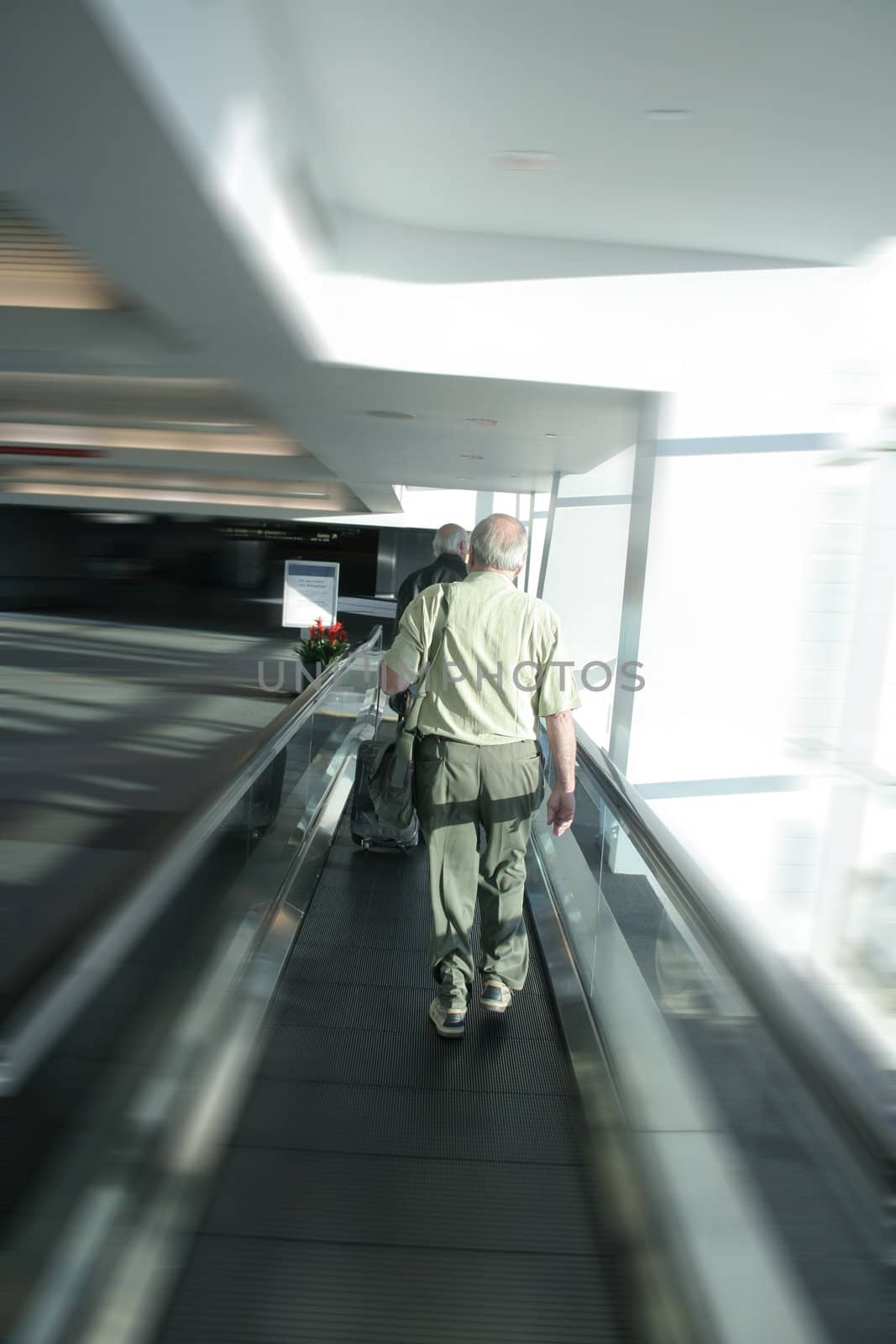 Man in airport on mechanical walkway