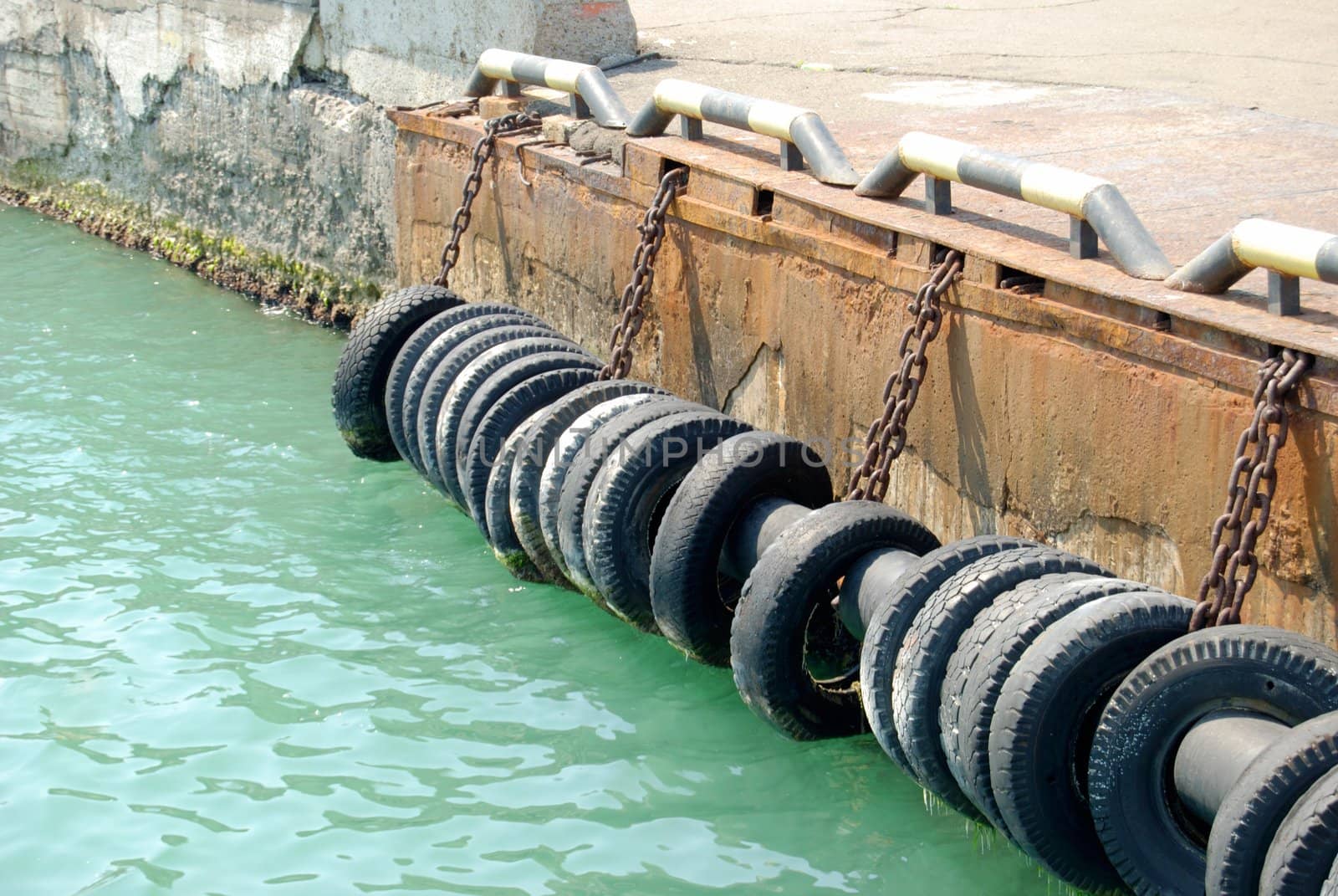 Old automobile tires, are adhered at a mooring