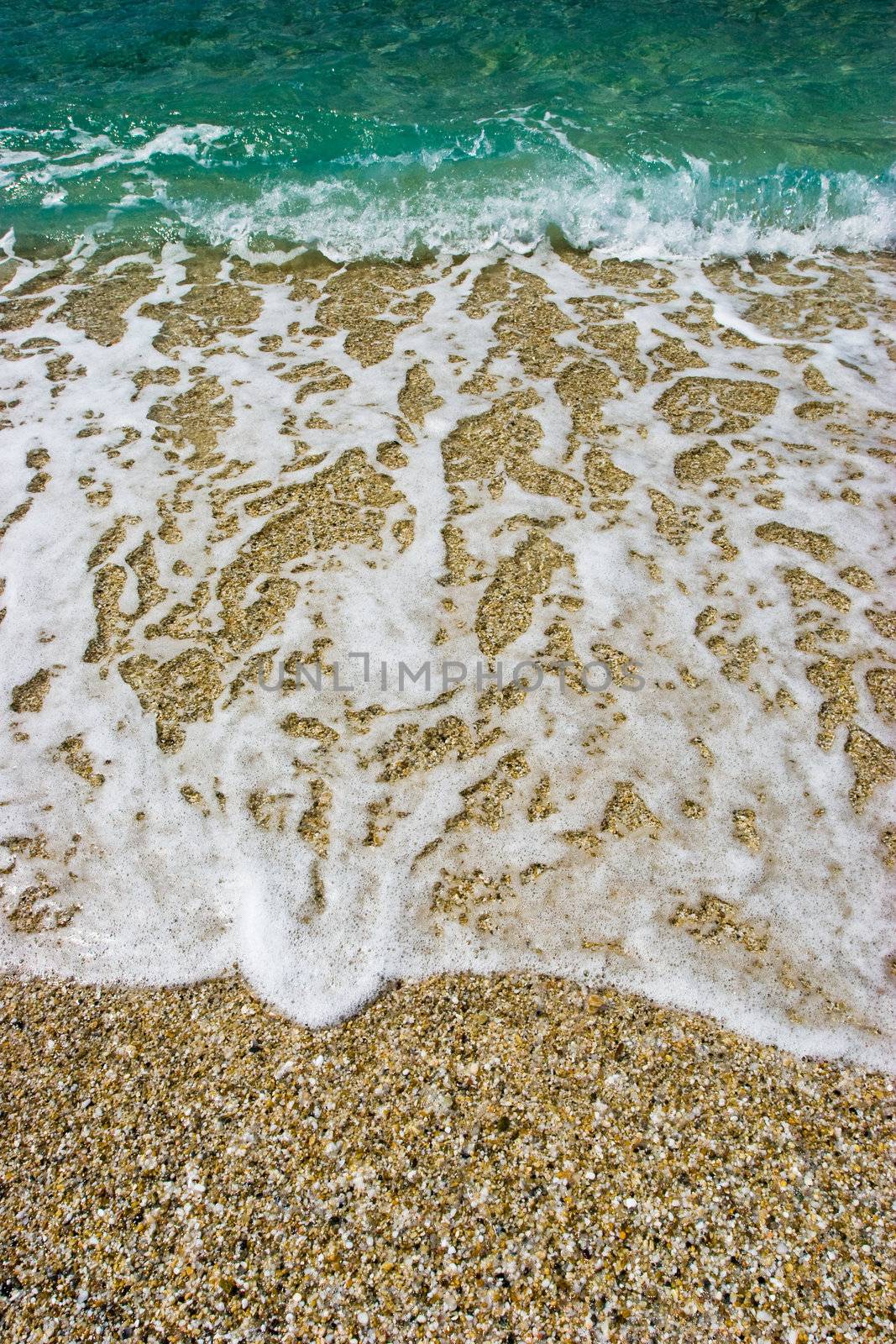 Waves on a pebbly sea shore background