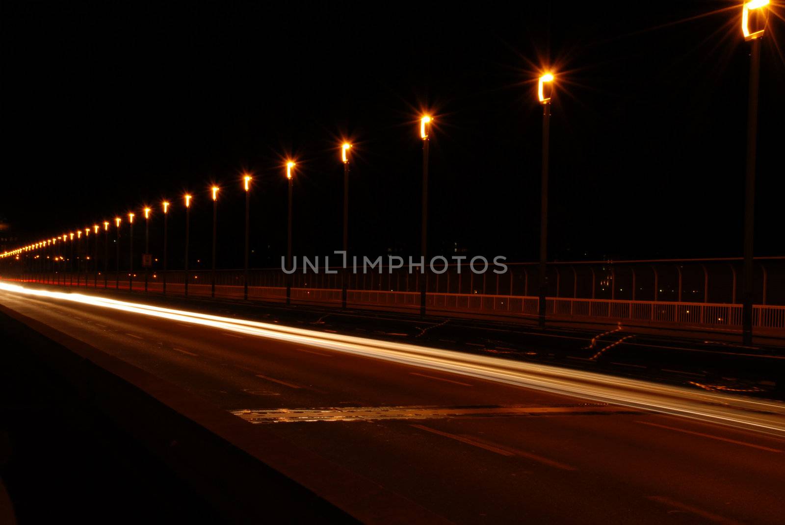 The traffic on the road on the bridge in Prague in the night