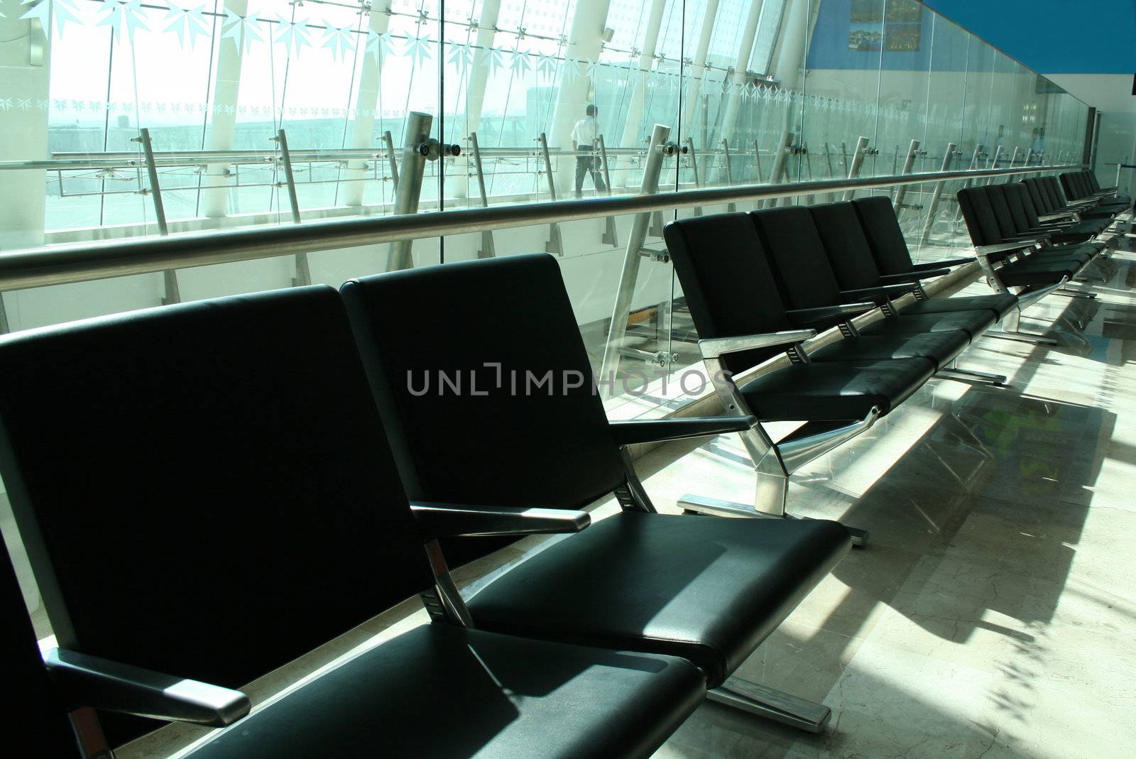 Empty seats at airport with security in background