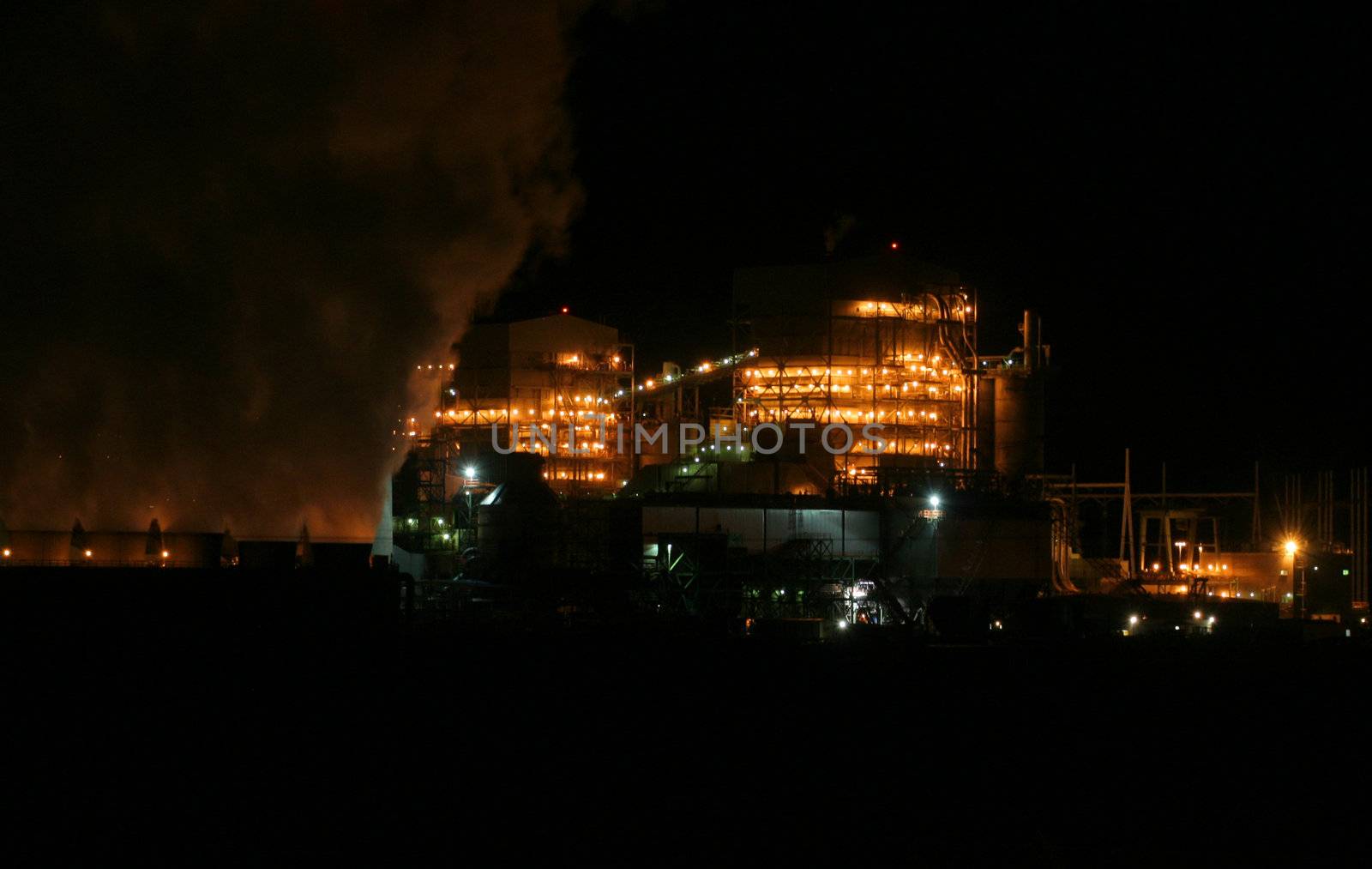 Factory with smoke stack at night