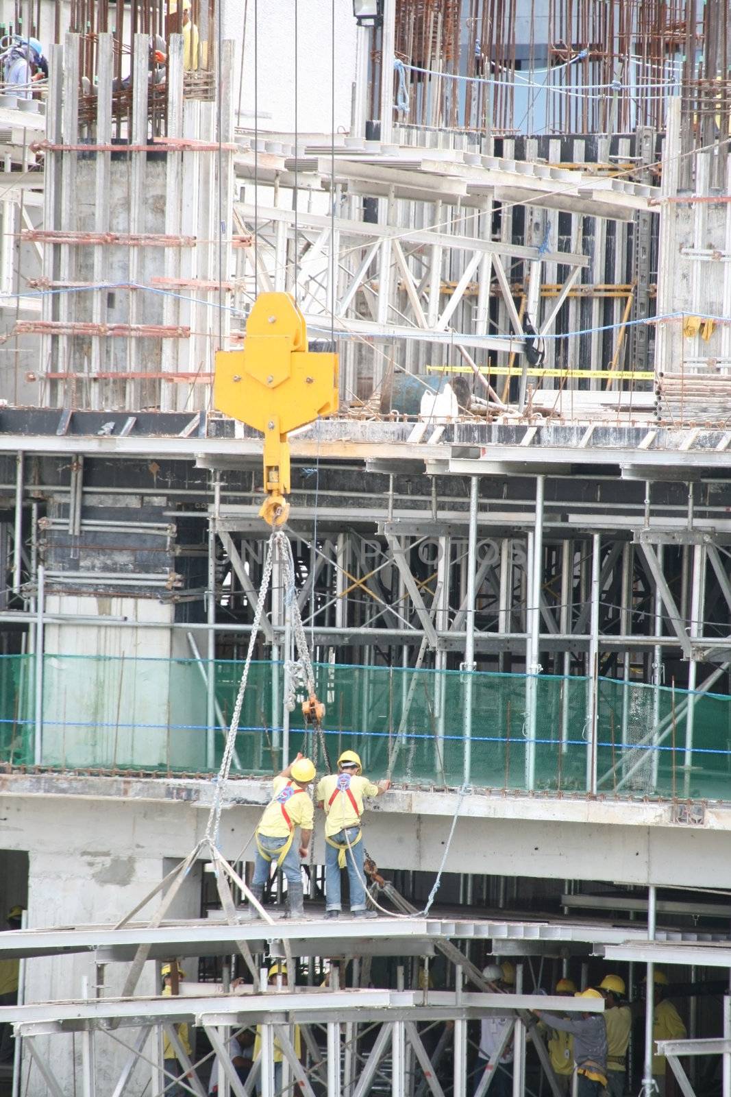 two construction workers pulling up at the edge of the building
