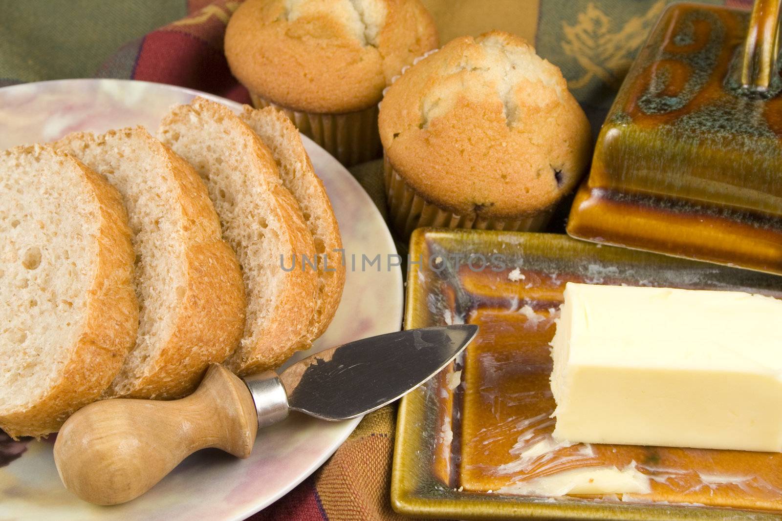 Bread and muffins with butter pad and plate