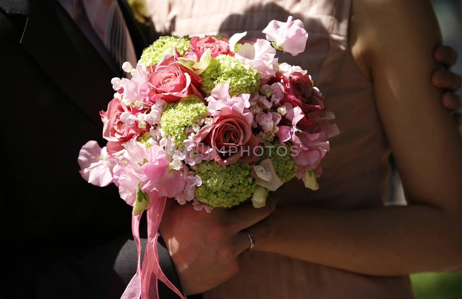 Wedding bouquet in hands of the groom and the bride
