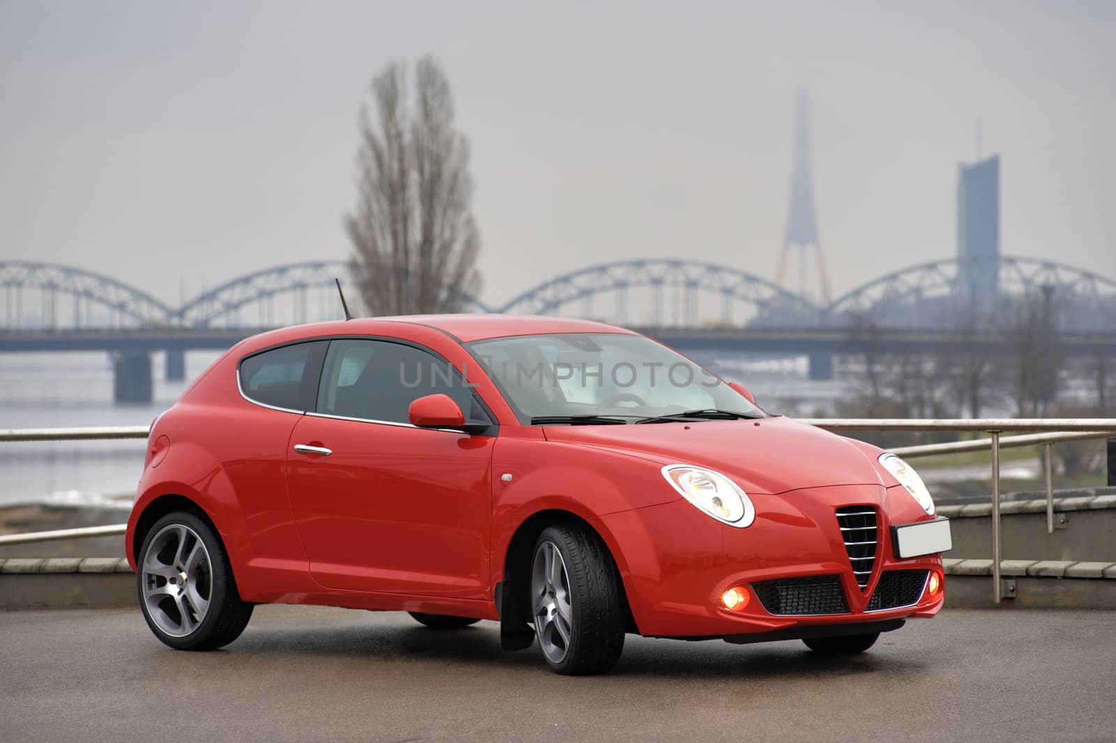 Red car parked on the background of the bridge, Riga, Latvia