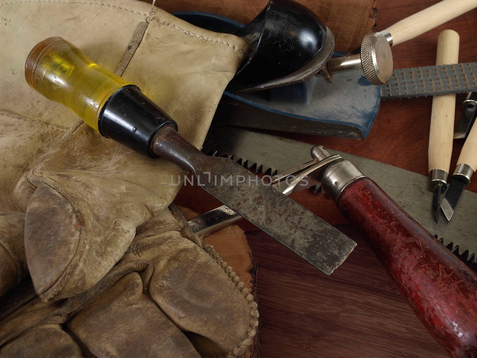 Various woodworking tools and gloves on a wood texture background.