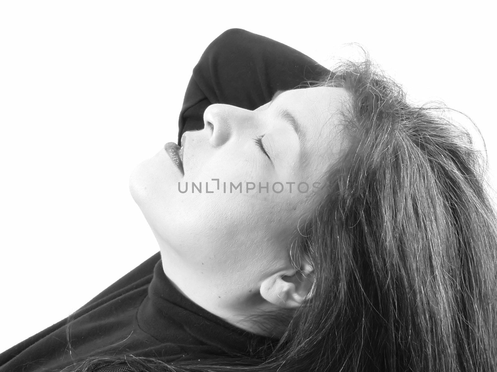A brunette woman closes her eyes and leans her head back. On a white background, in black and white.