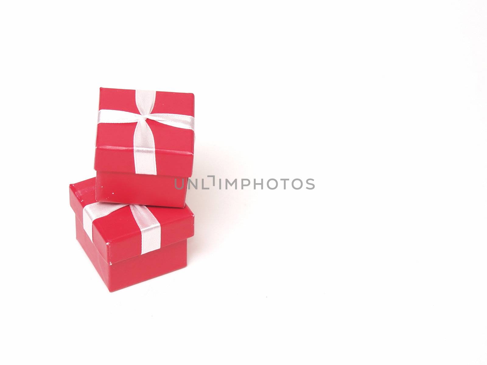 Two little red giftboxes, stacked, on an isolated white background.
