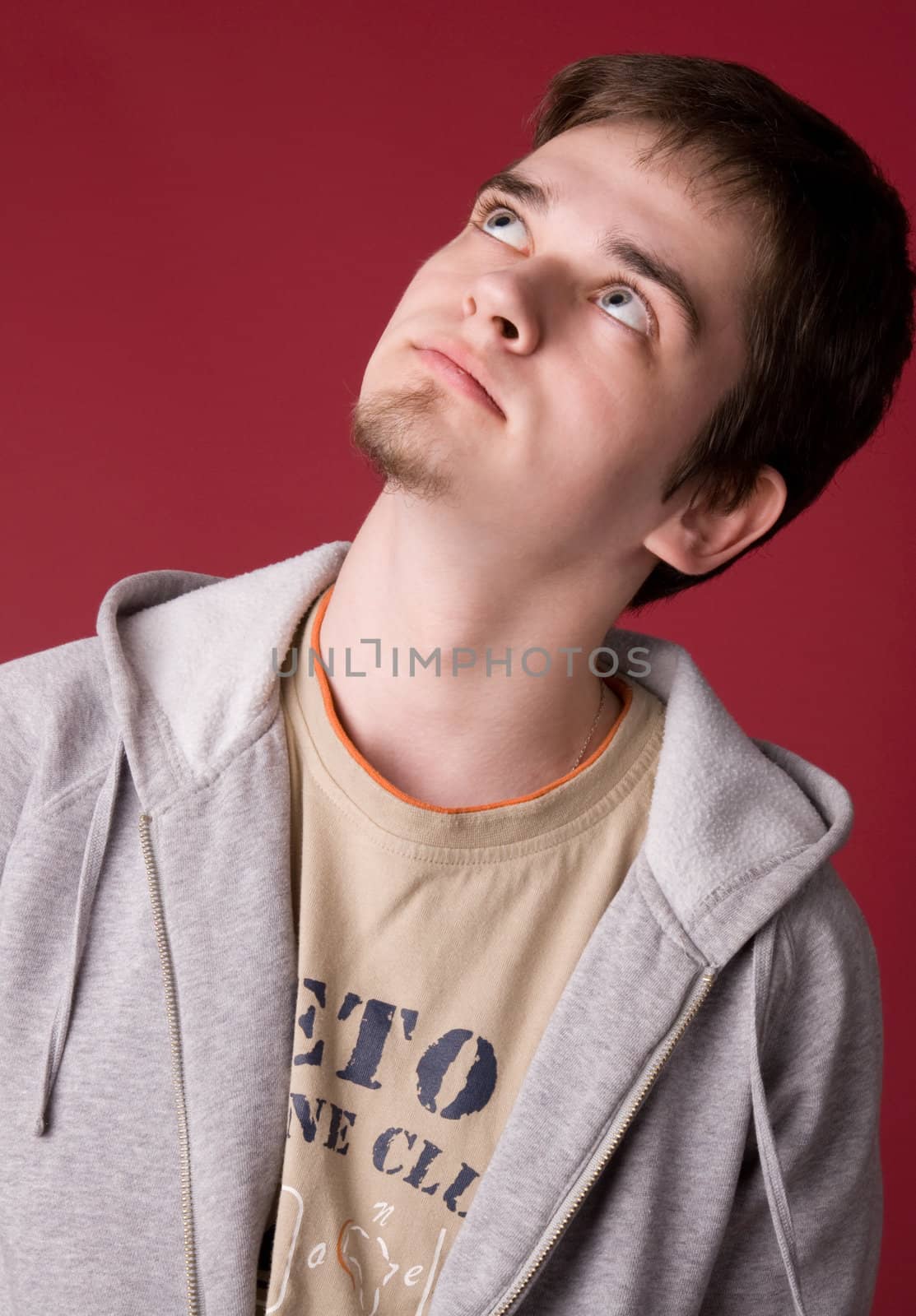 The young guy in studio on a red background