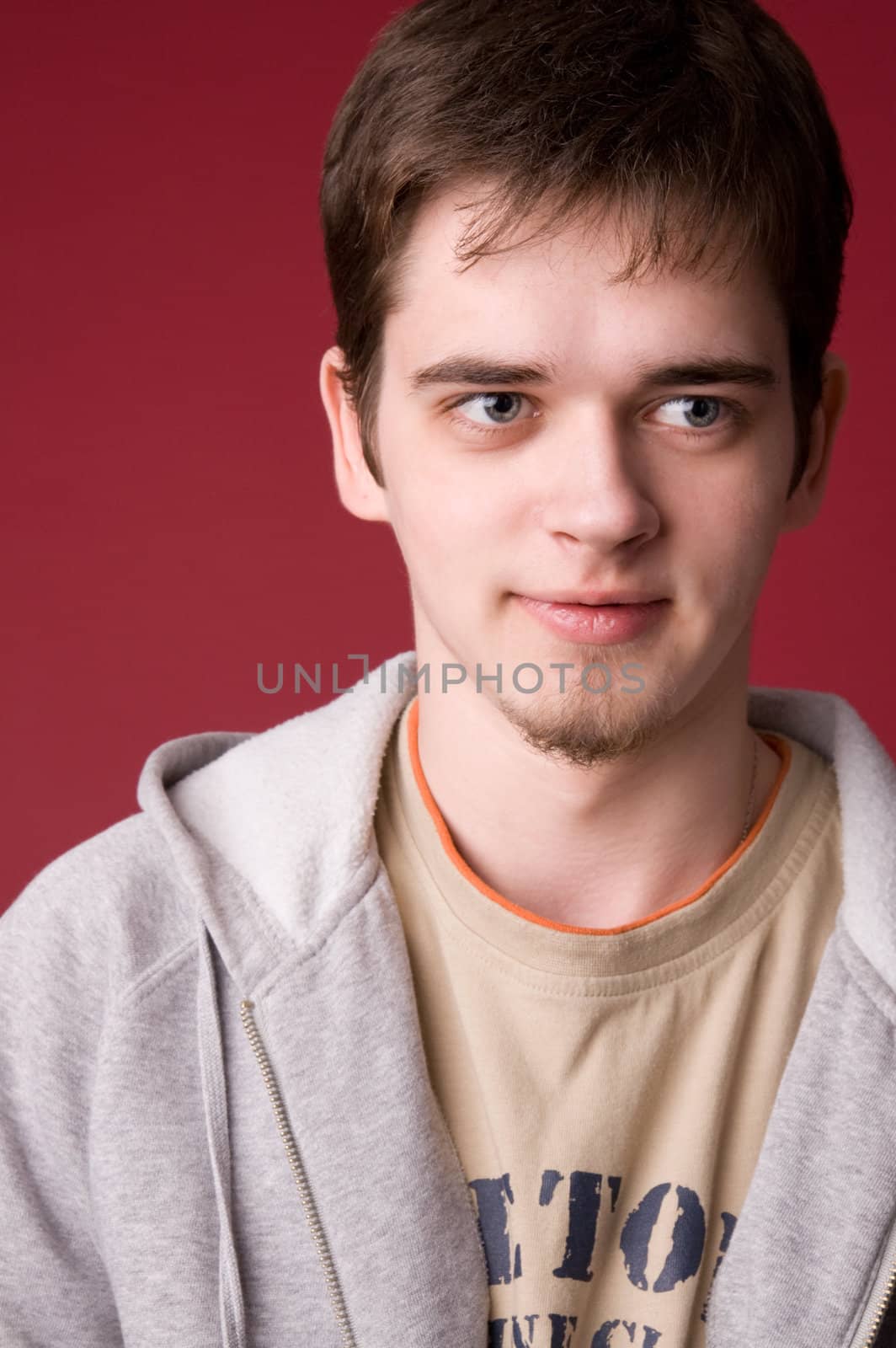 The young guy in studio on a red background