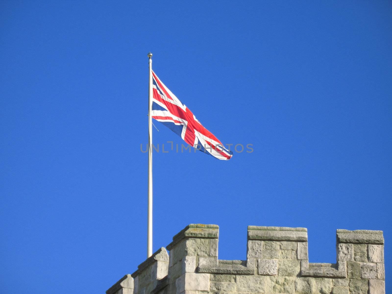 Union flag on castellated turret against deep blue sky