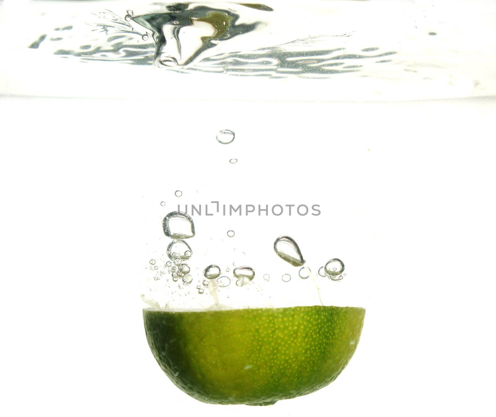 Splash of green lemon to water with bubbles of air