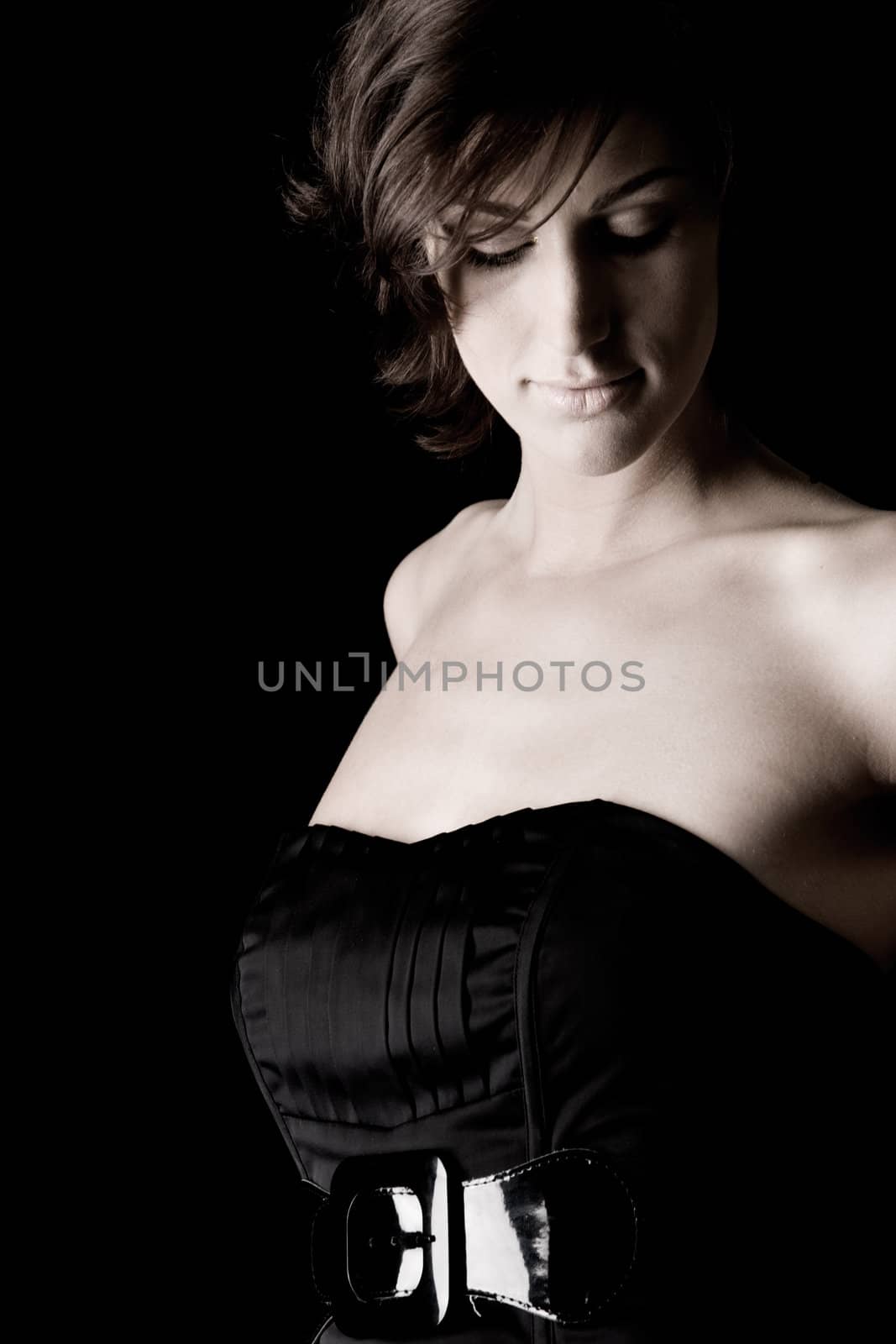 Studio portrait of a tall lady in a black dress on a black background