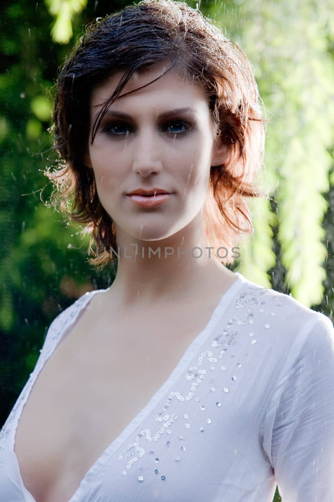 Brunette in see through blouse standing in the rain