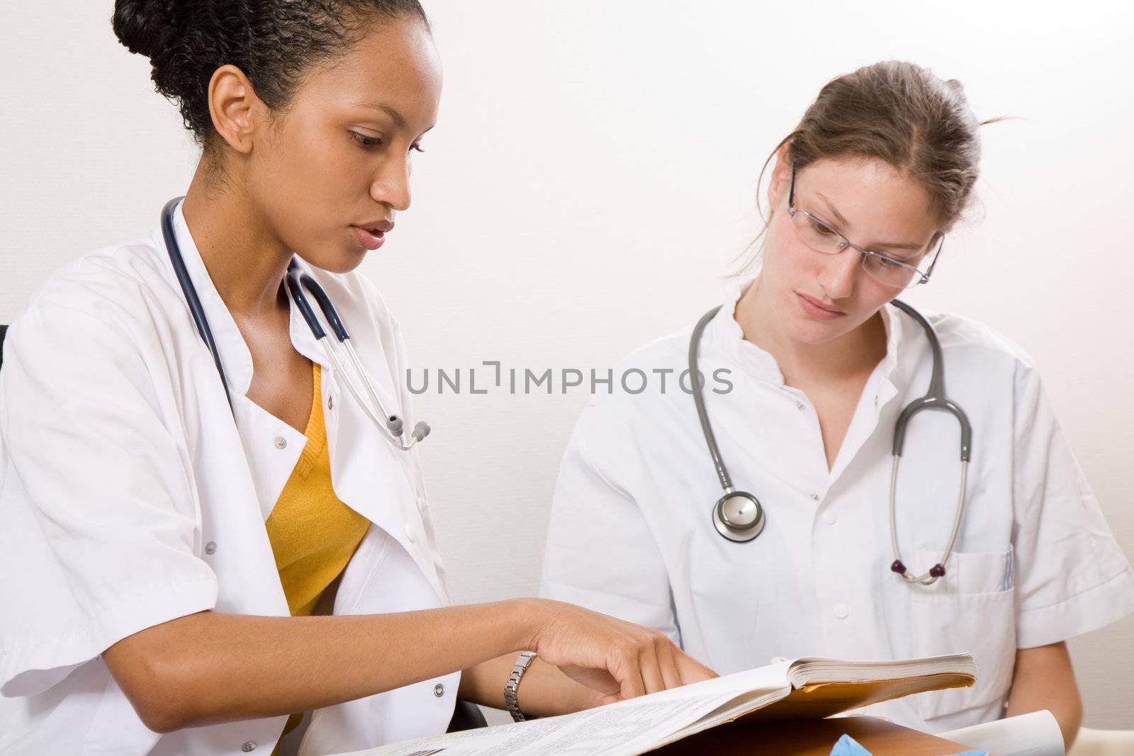 Two medical students looking through the books together