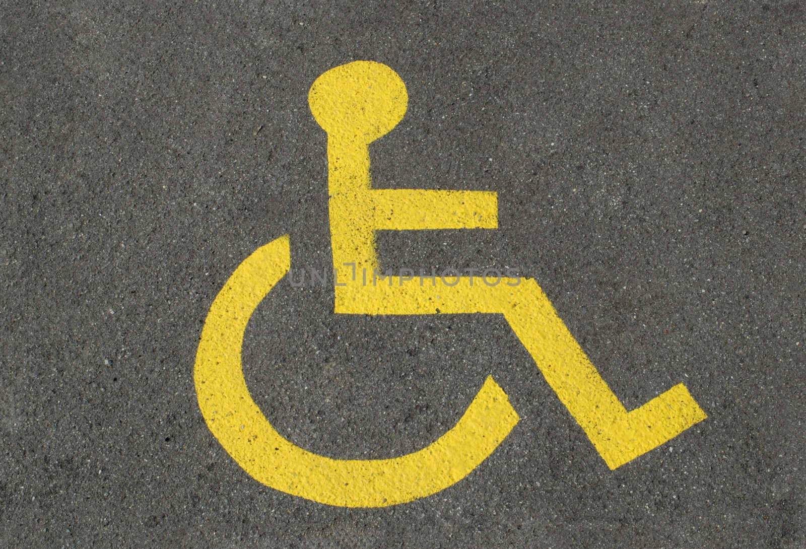 A sign for disabled parking, on asphalt.