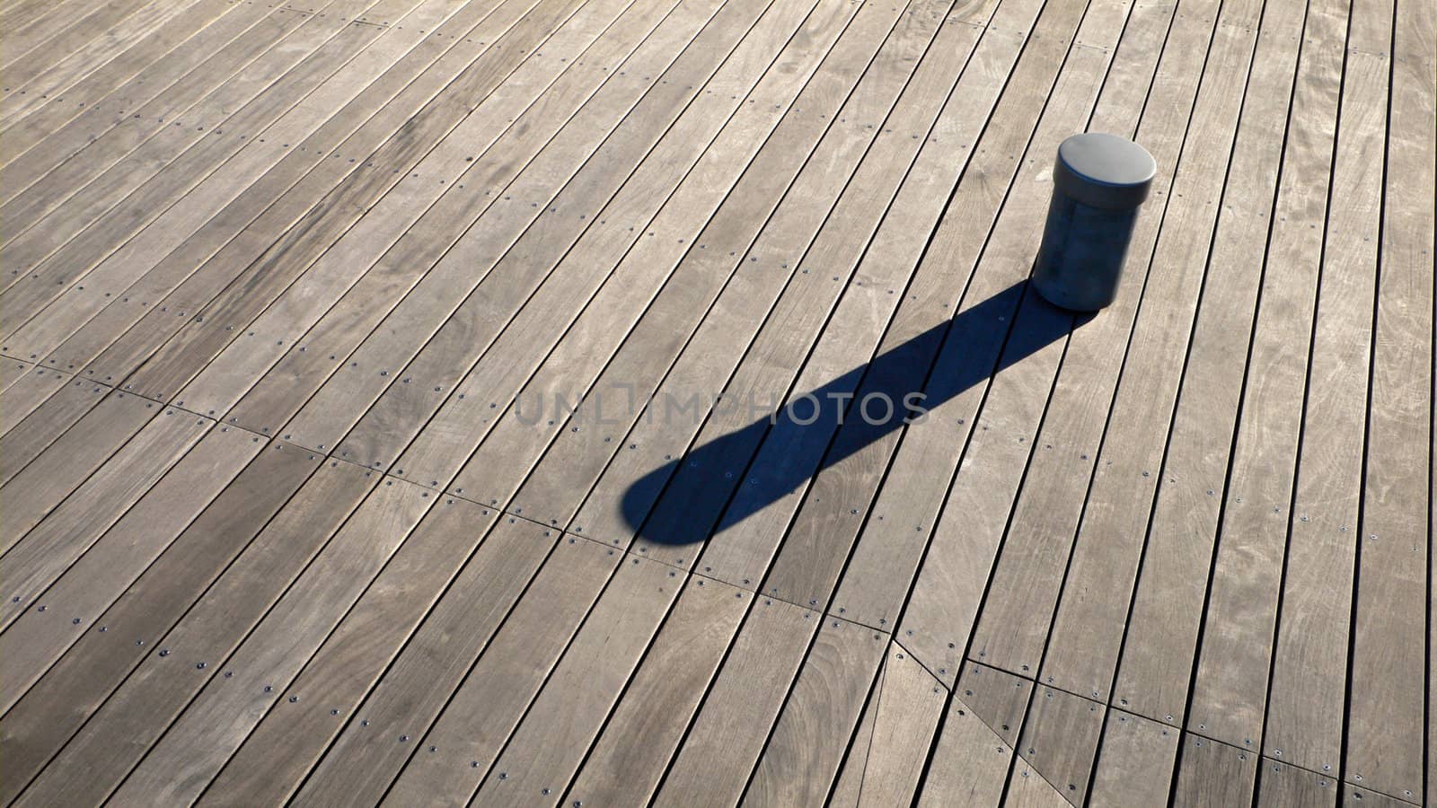small post and it's long shadow on the wooden deck background