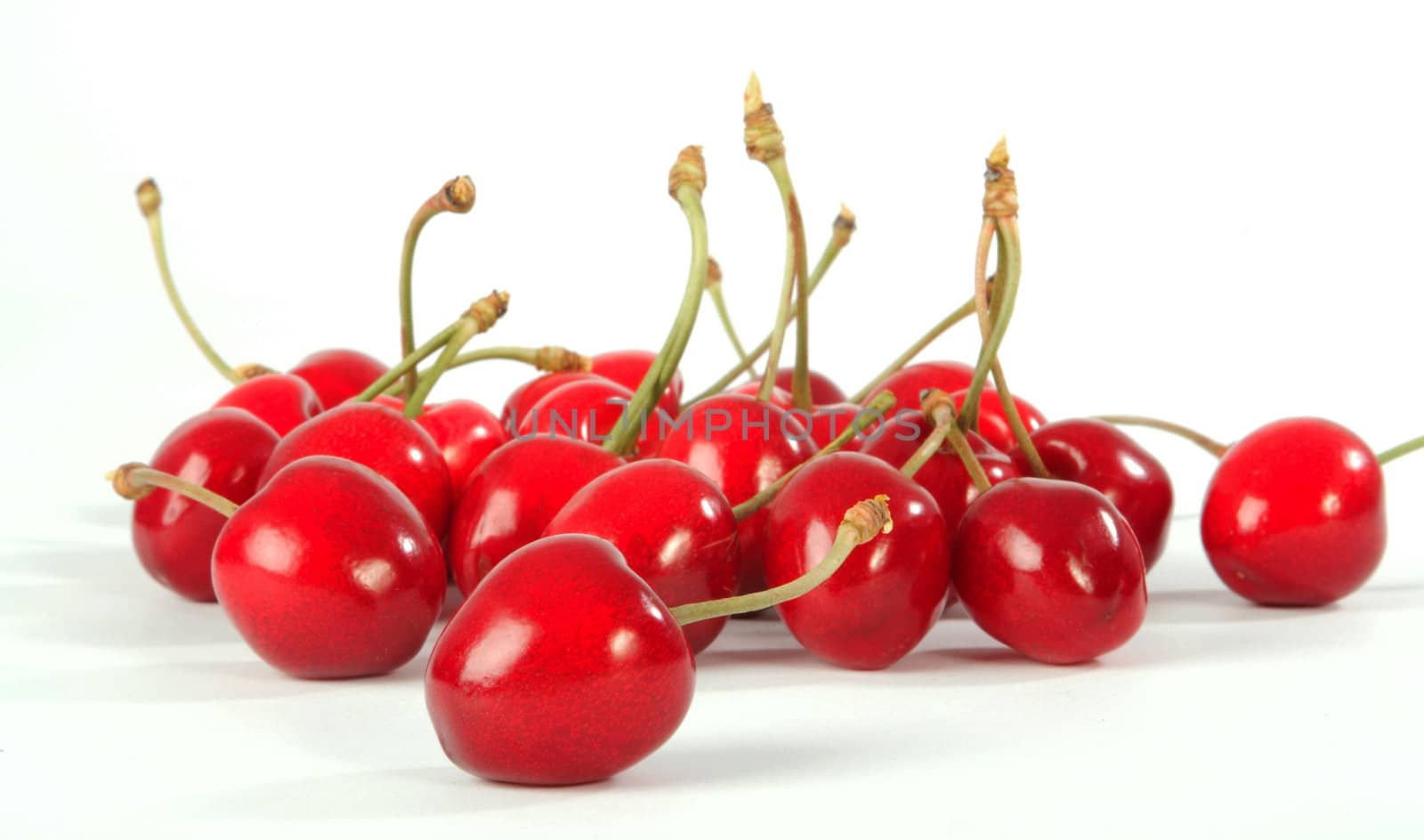 Ripe berries of a sweet cherry on a white sheet