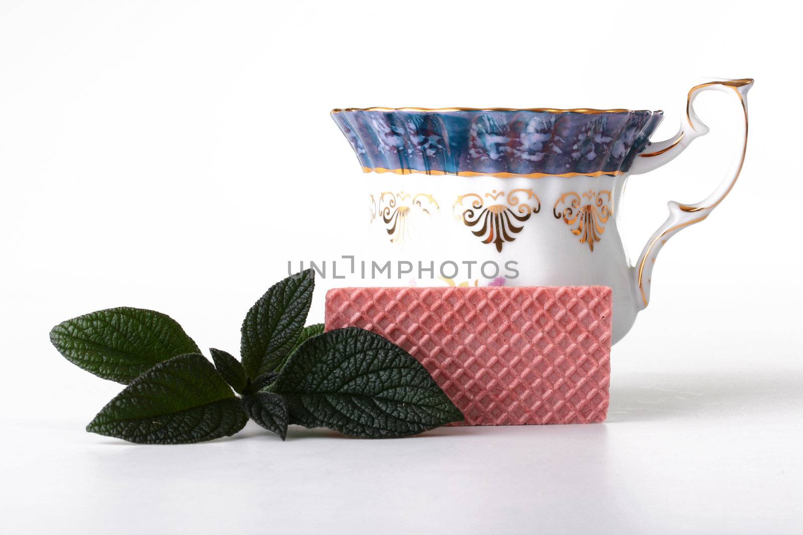 Wafer by a breakfast with a cup of tea and mint leaves.