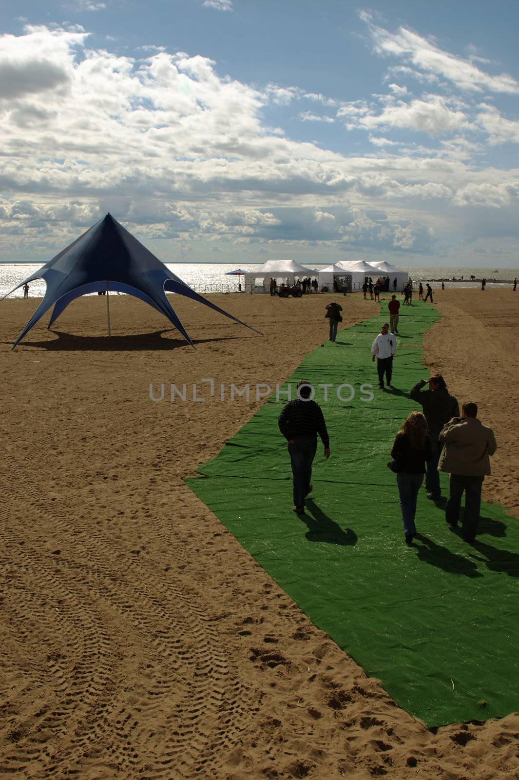 Group of people going on a beach, on a green carpet