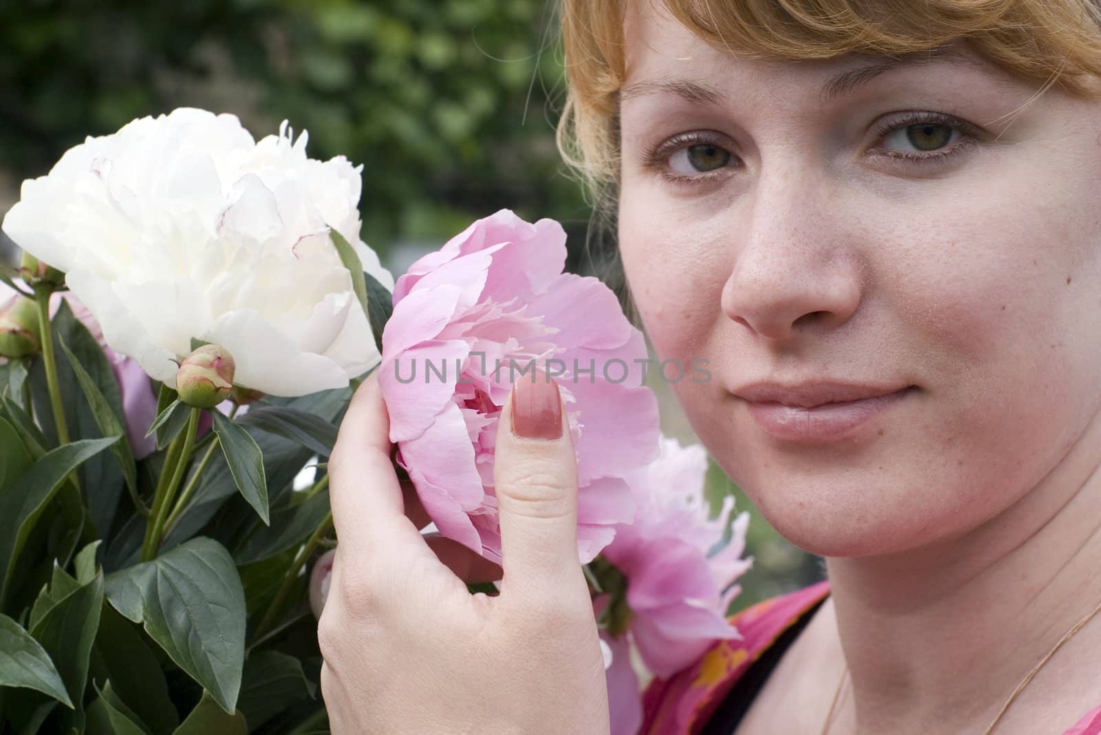 Beautiful young woman holding pink peony