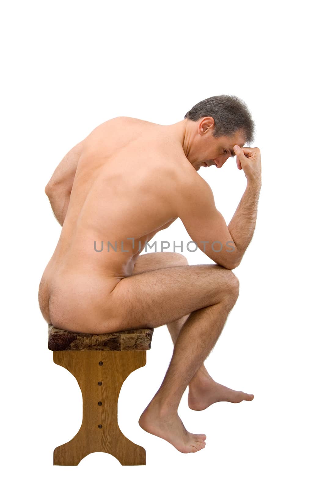 The man sits on a chair in a thoughtful pose
