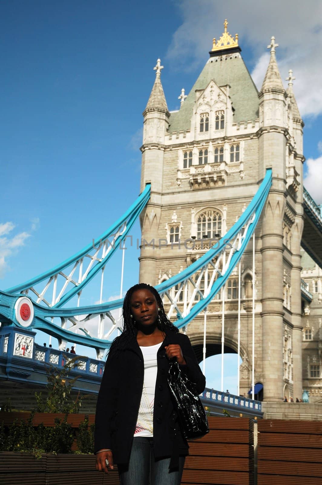african girl standing in front of London tower bridge in nice autumn