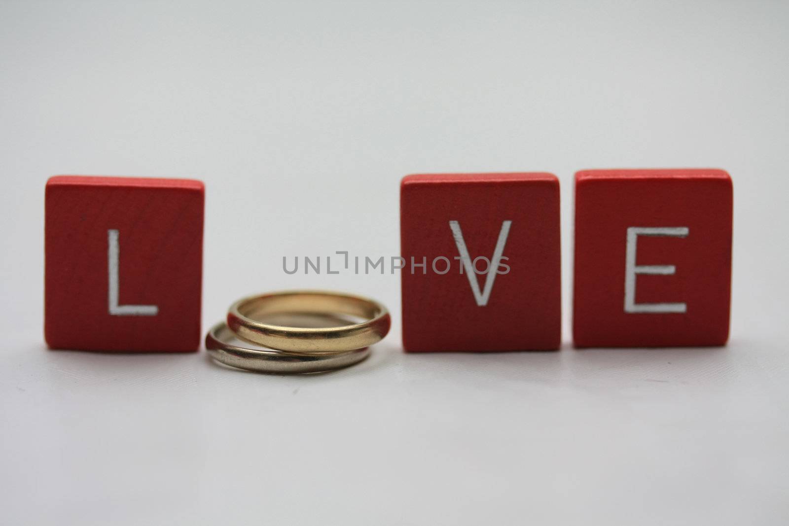 Red wooden letters with simple plain wedding bands.