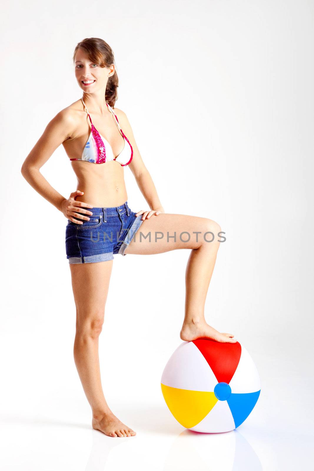 Beautiful young woman posing in bikini with a beach ball