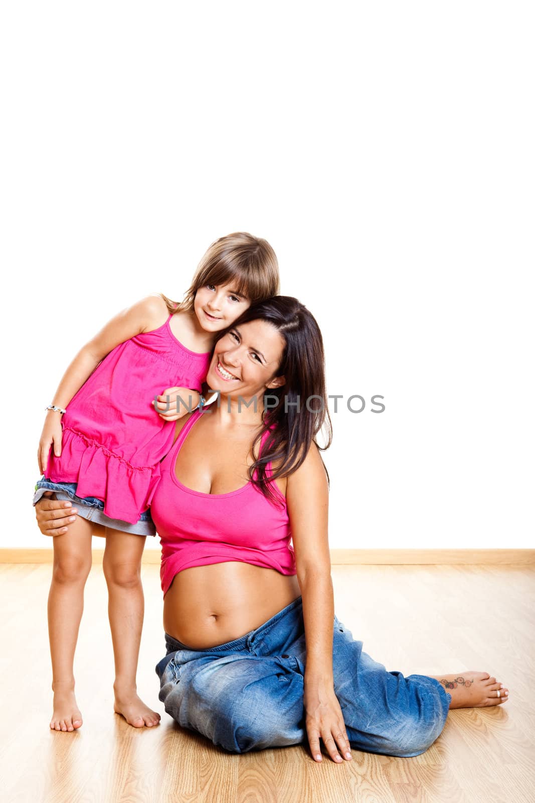 Beautiful pregnant mother with her daughter isolated on white
