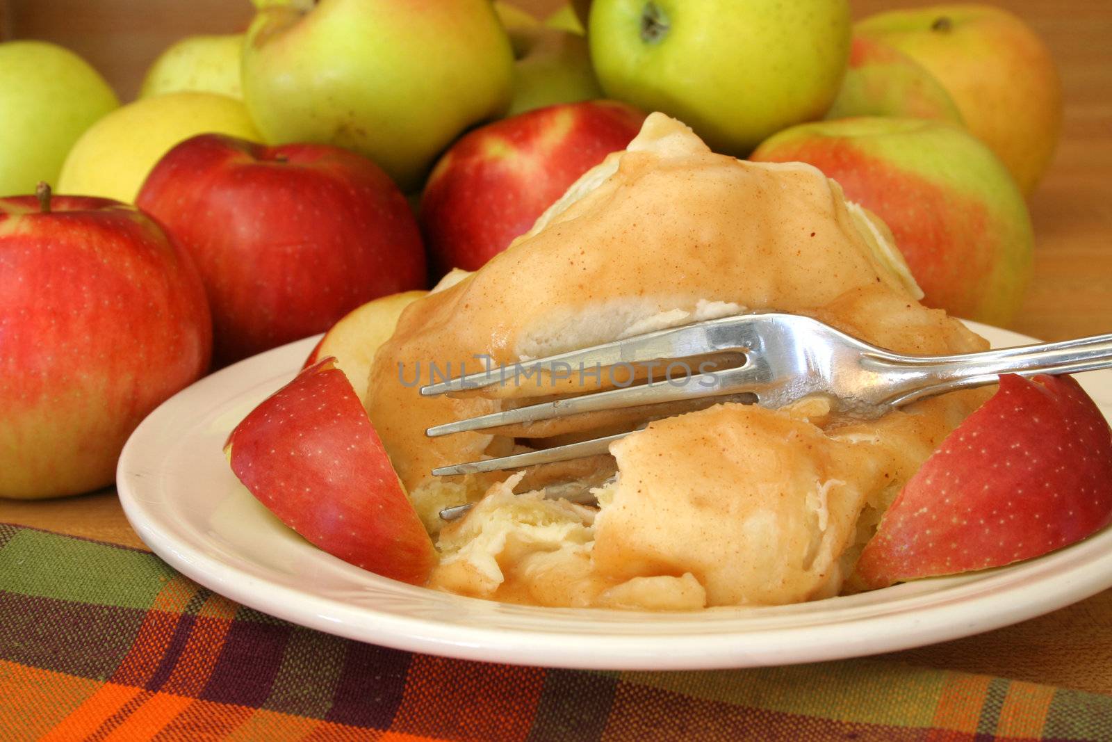 Home made apple dumpling with a group of apples in the background.

