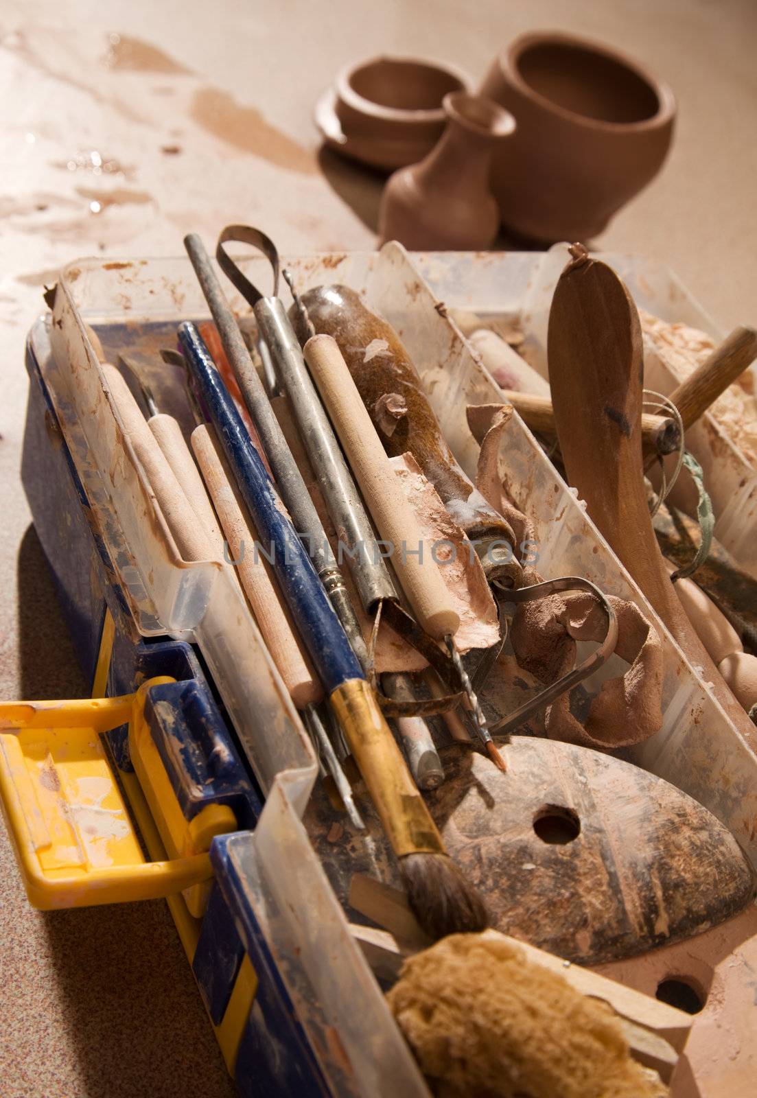 Tools for forming clay with pots in background